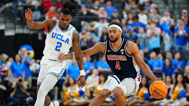 Arizona Wildcats guard Kylan Boswell dribbles against UCLA Bruins guard Dylan Andrews.